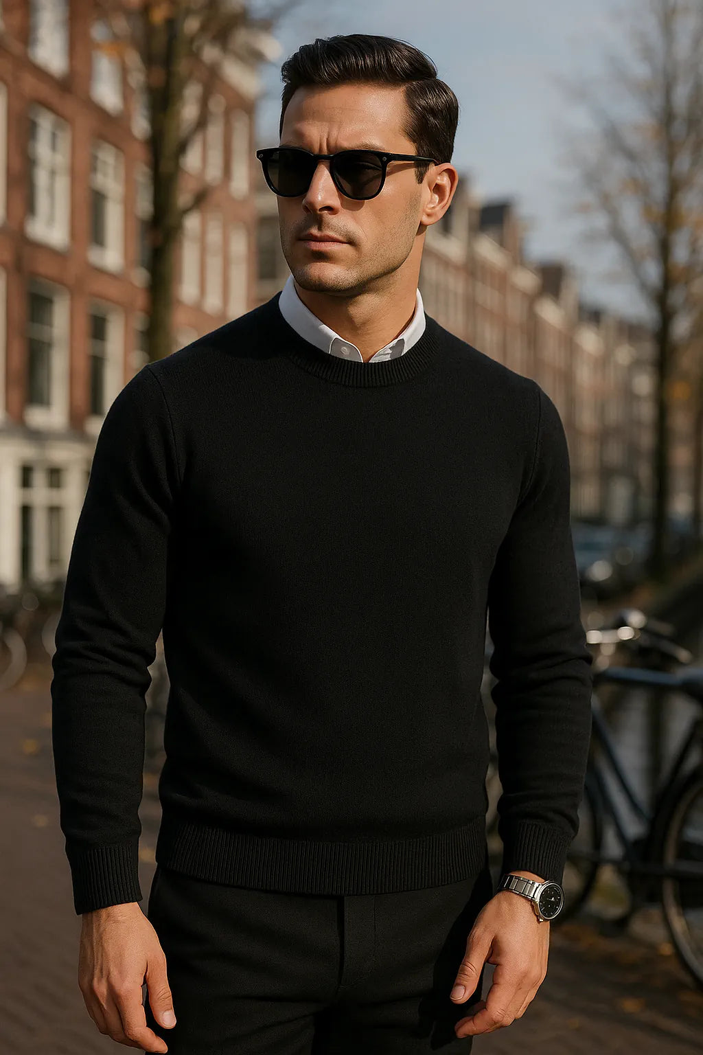Man wearing a black sweater and sunglasses on a city street.
