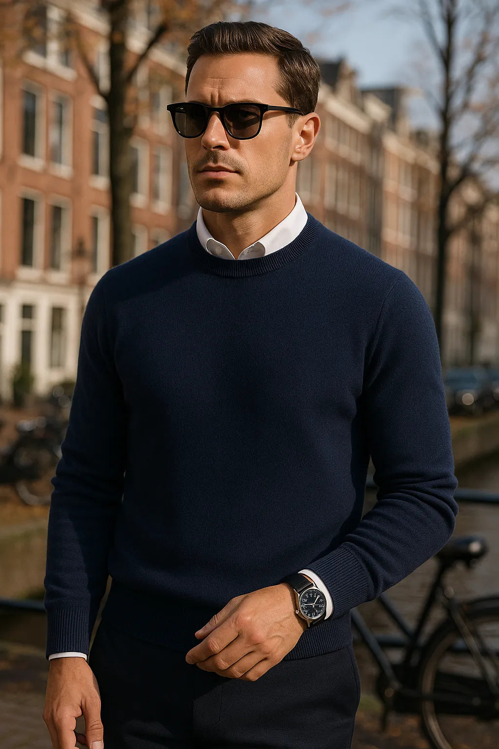 Man wearing a navy sweater and sunglasses in an urban setting