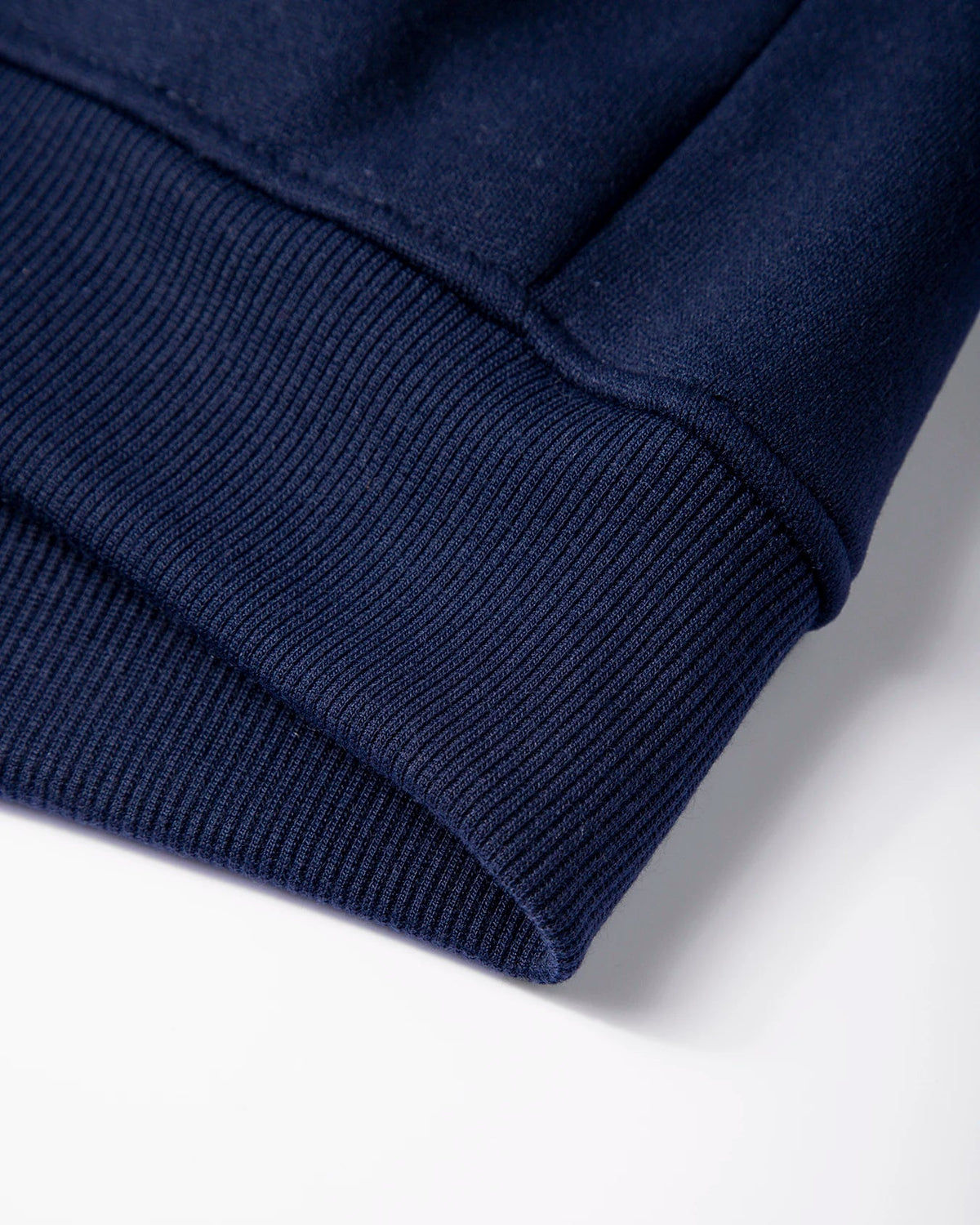 Close-up of a navy blue sweater sleeve on a white background