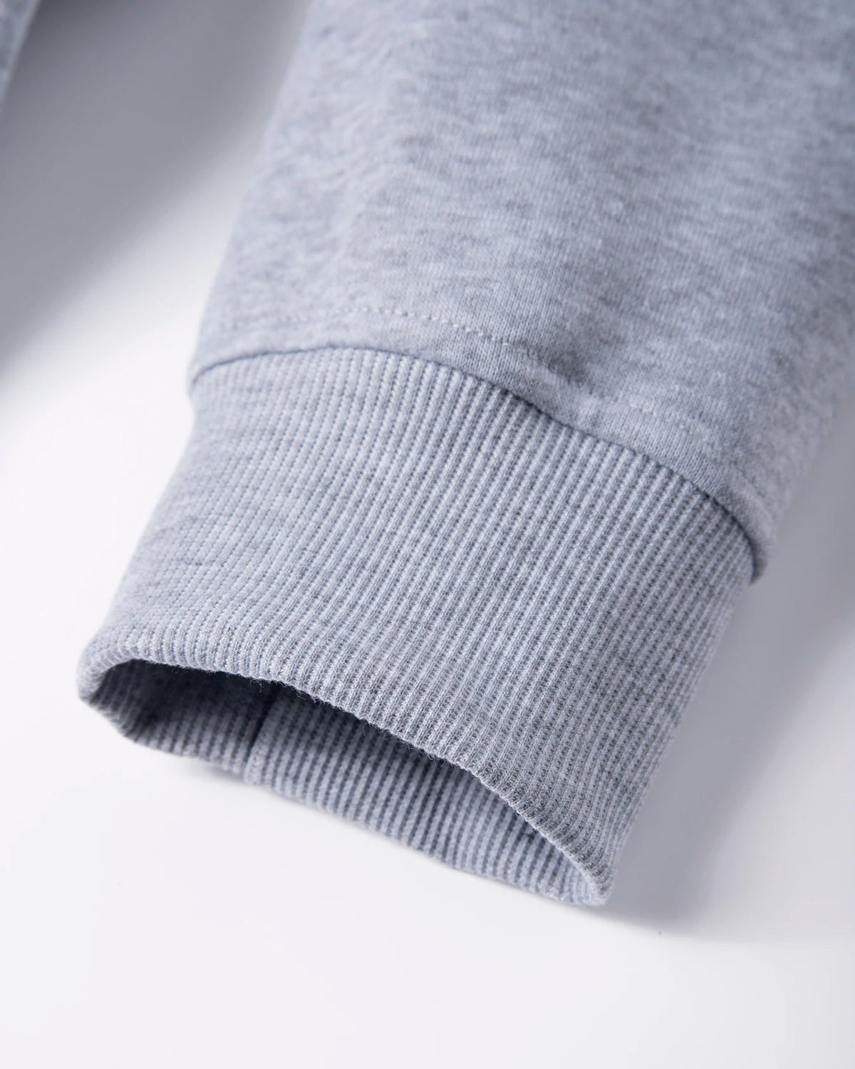 Close-up of a gray sweatshirt sleeve on a light gray background