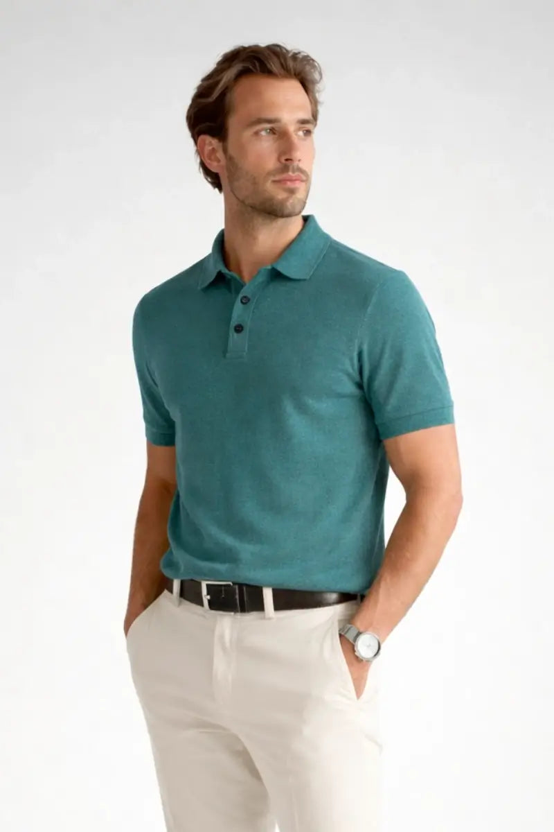 Man wearing a teal polo shirt and white pants on a white background