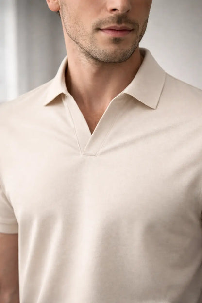 Man wearing a beige polo shirt against a neutral background