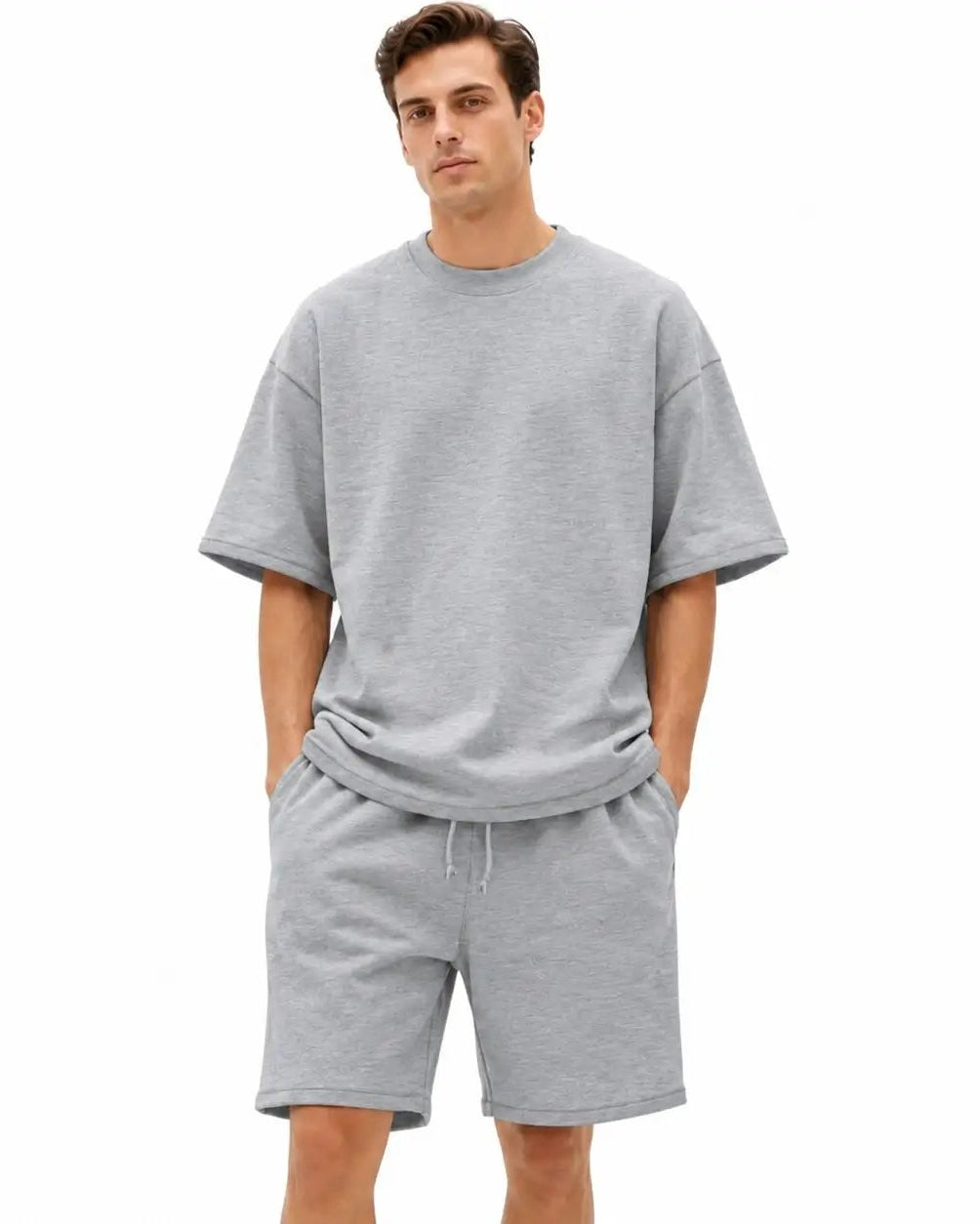 A man modeling a light gray heathered short-sleeve crewneck t-shirt and matching drawstring shorts against a plain white background.