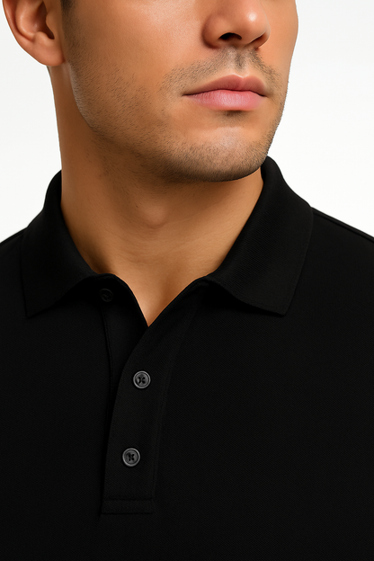 Close-up of a person wearing a black polo shirt with a plain background