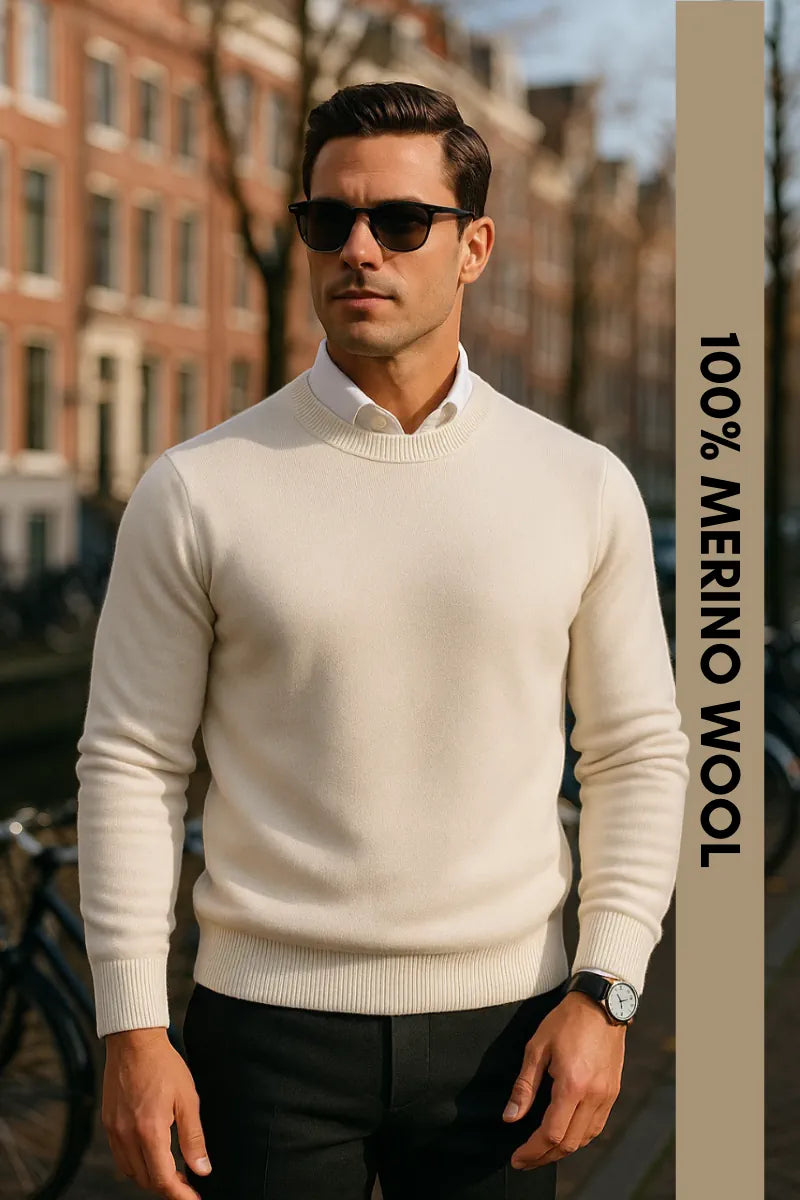 Man wearing a white merino wool sweater with text indicating material, standing outdoors.